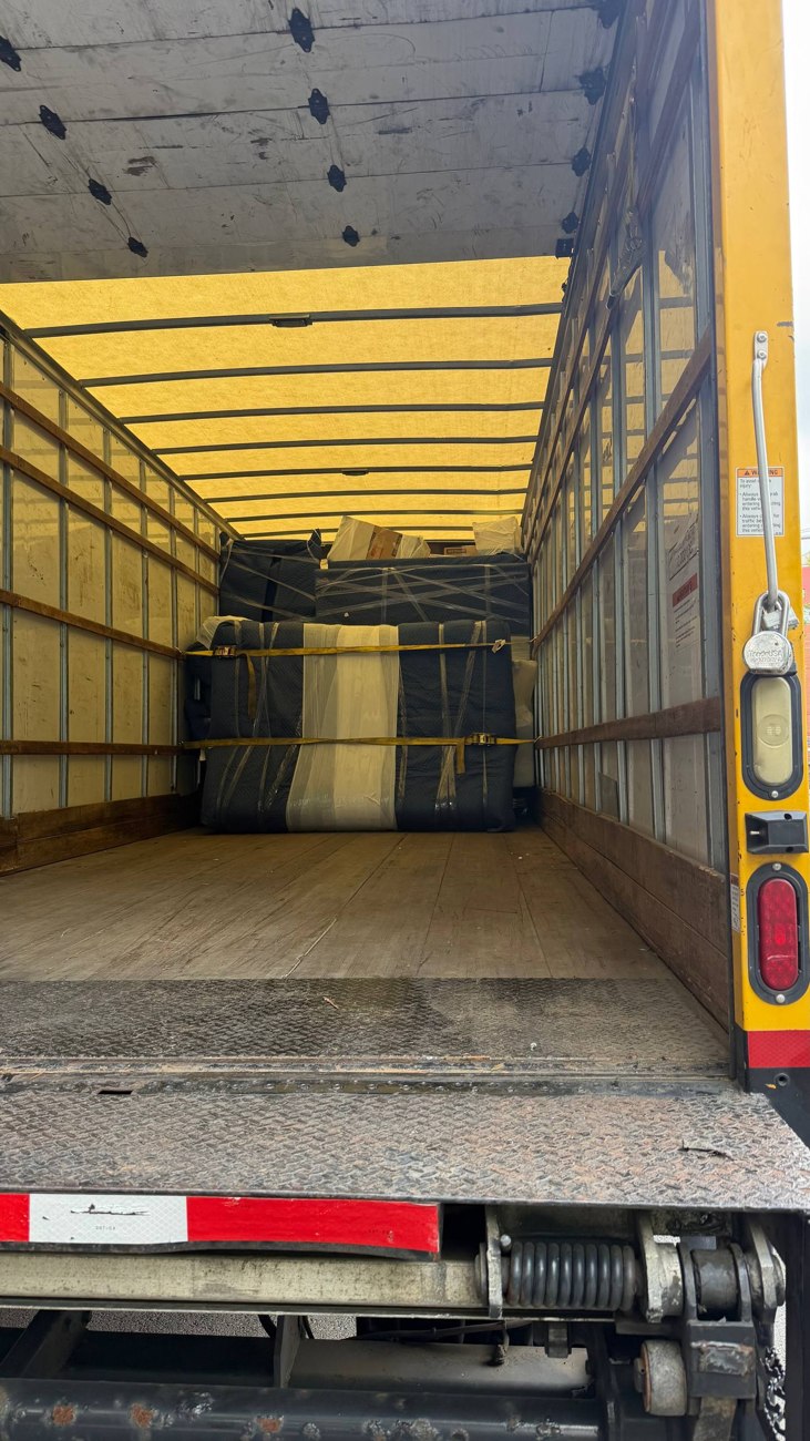 Protected furniture secured with straps in a moving truck