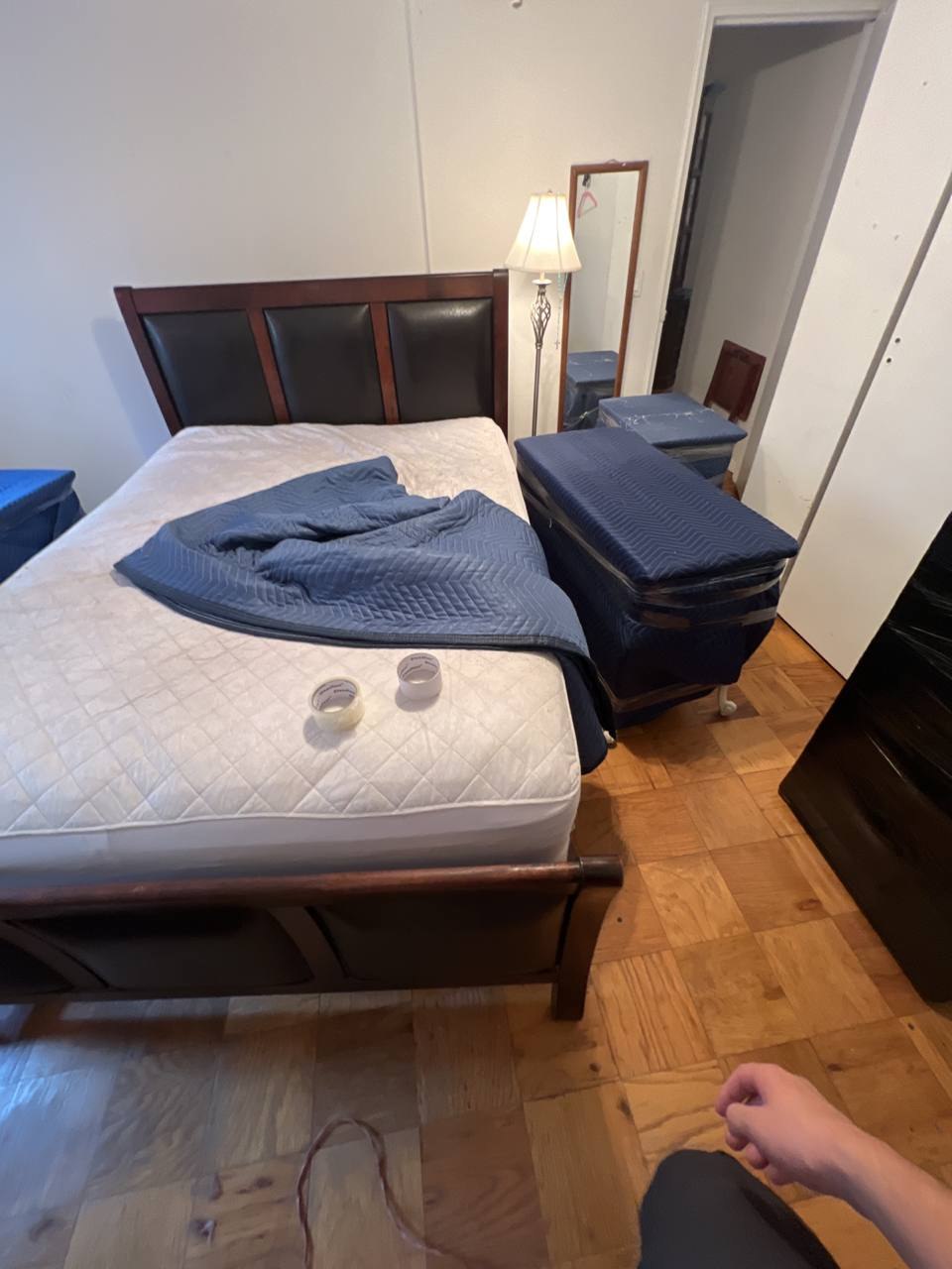 Bedroom with bedside furniture wrapped and prepared for moving
